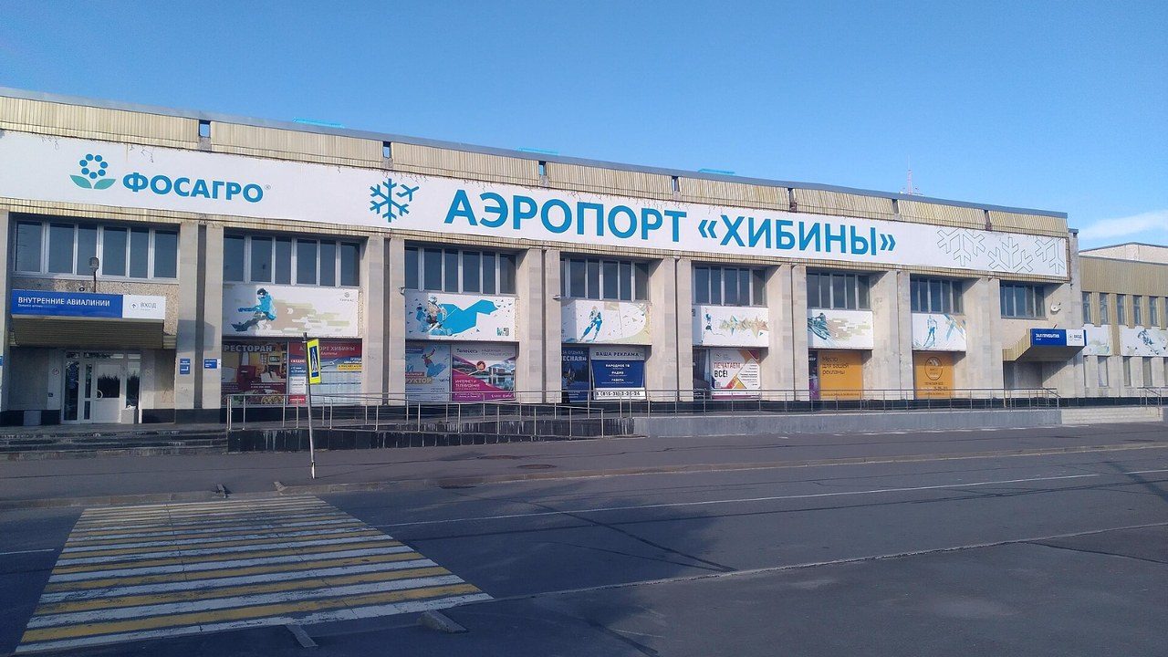 Здание аэропорта «Хибины» в Апатитах с вывеской на фасаде в солнечный день
